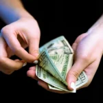 Mano con billetes de dólar