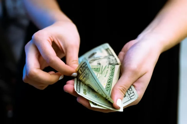 Mano con billetes de dólar